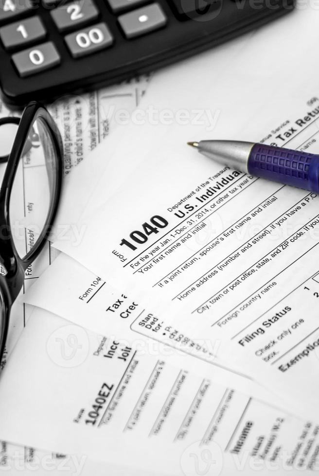 oss skatteformulär 1040 med penna, glasögon och miniräknare foto