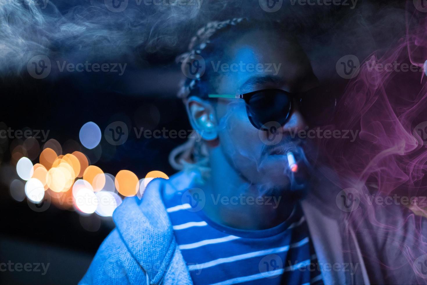 afrikansk amerikansk man röker cigarett på natten foto