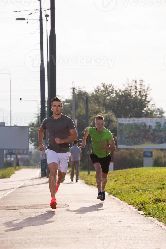 två unga män som joggar genom staden foto