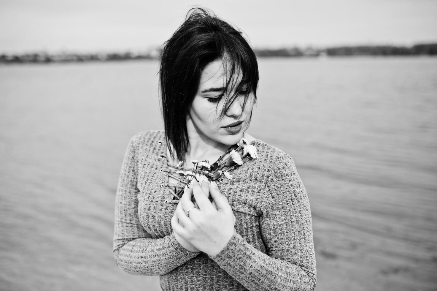 porträtt av brunett flicka i grå klänning bakgrund sjön. foto