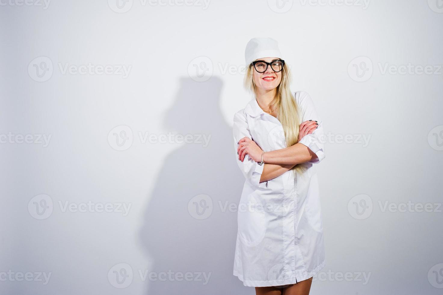 attraktiv blond kvinnlig läkare eller sjuksköterska i labbrock och glasögon isolerad på vit bakgrund. foto