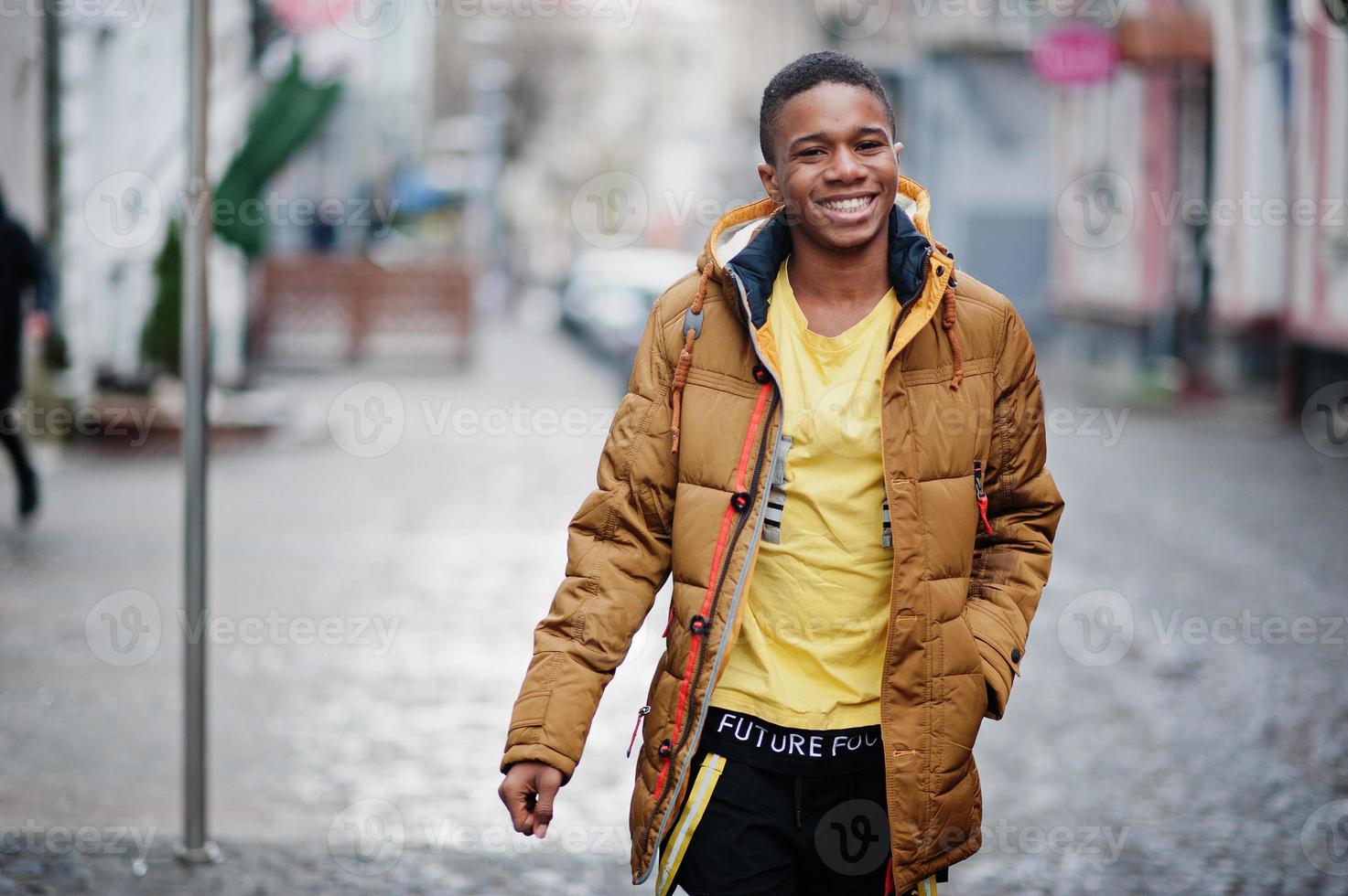 afrikansk man bär på jacka vid kallt väder poserade utomhus. foto