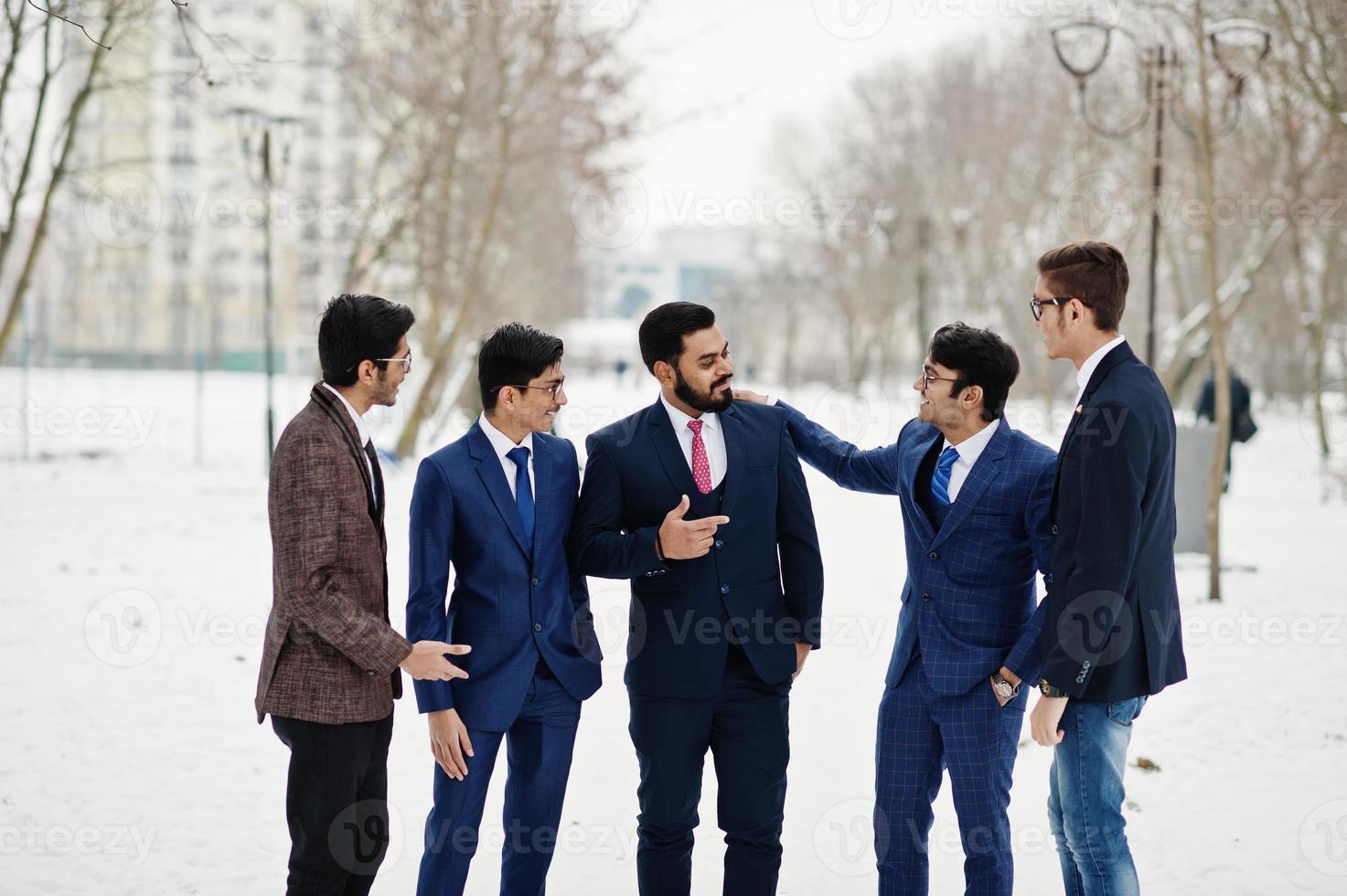 grupp av fem indisk affärsman i kostym poserade utomhus och föra en diskussion i vinterdag i Europa. foto