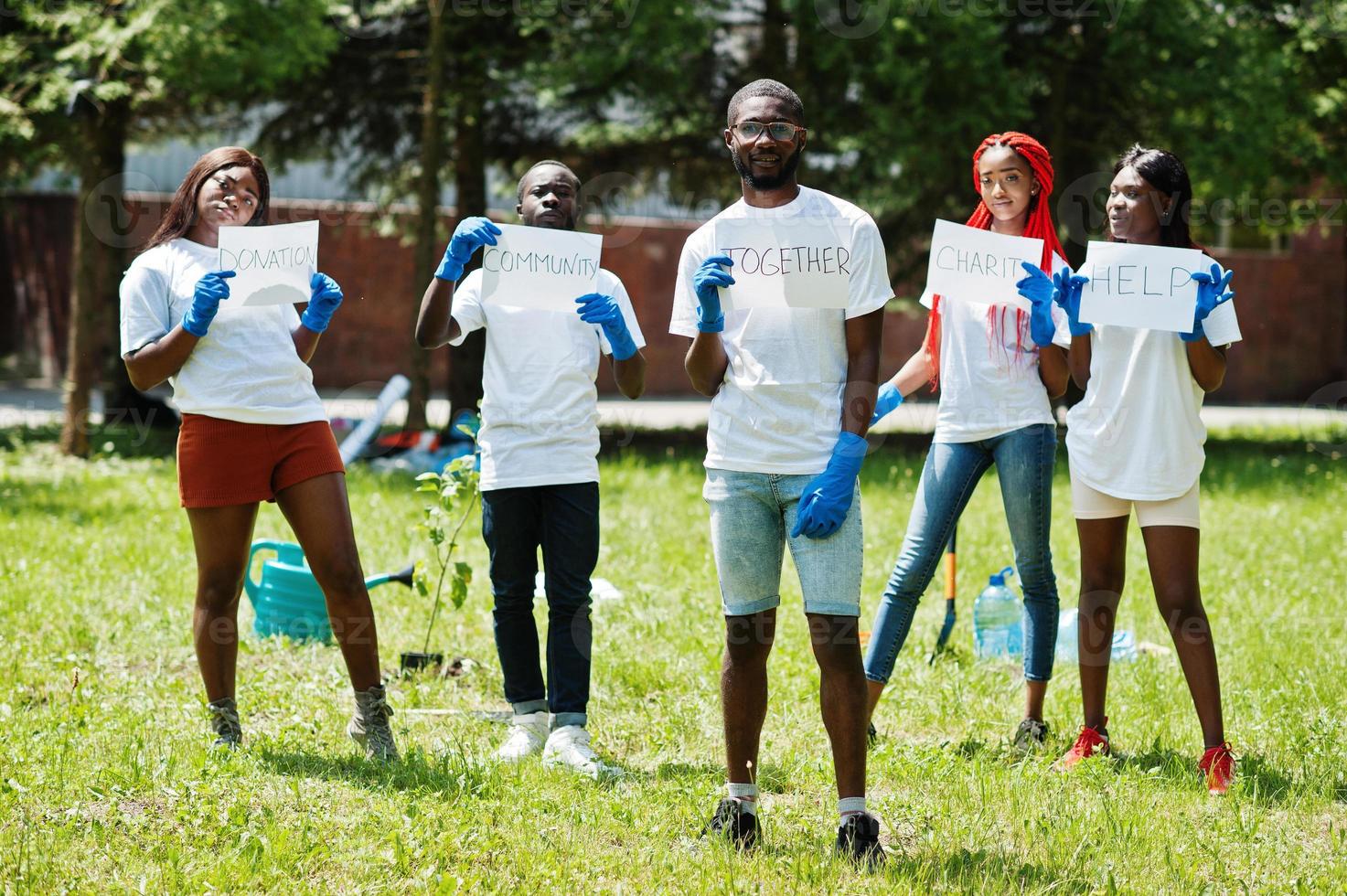 grupp glada afrikanska volontärer håller tom tavla med tillsammans logga i parken. Afrika volontärarbete, välgörenhet, människor och ekologi koncept. foto