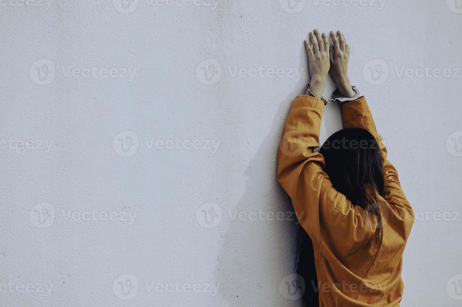 fånge i orange dräktkoncept, porträtt av asiatisk kvinna i fängelseuniformer på vit bakgrund, foto