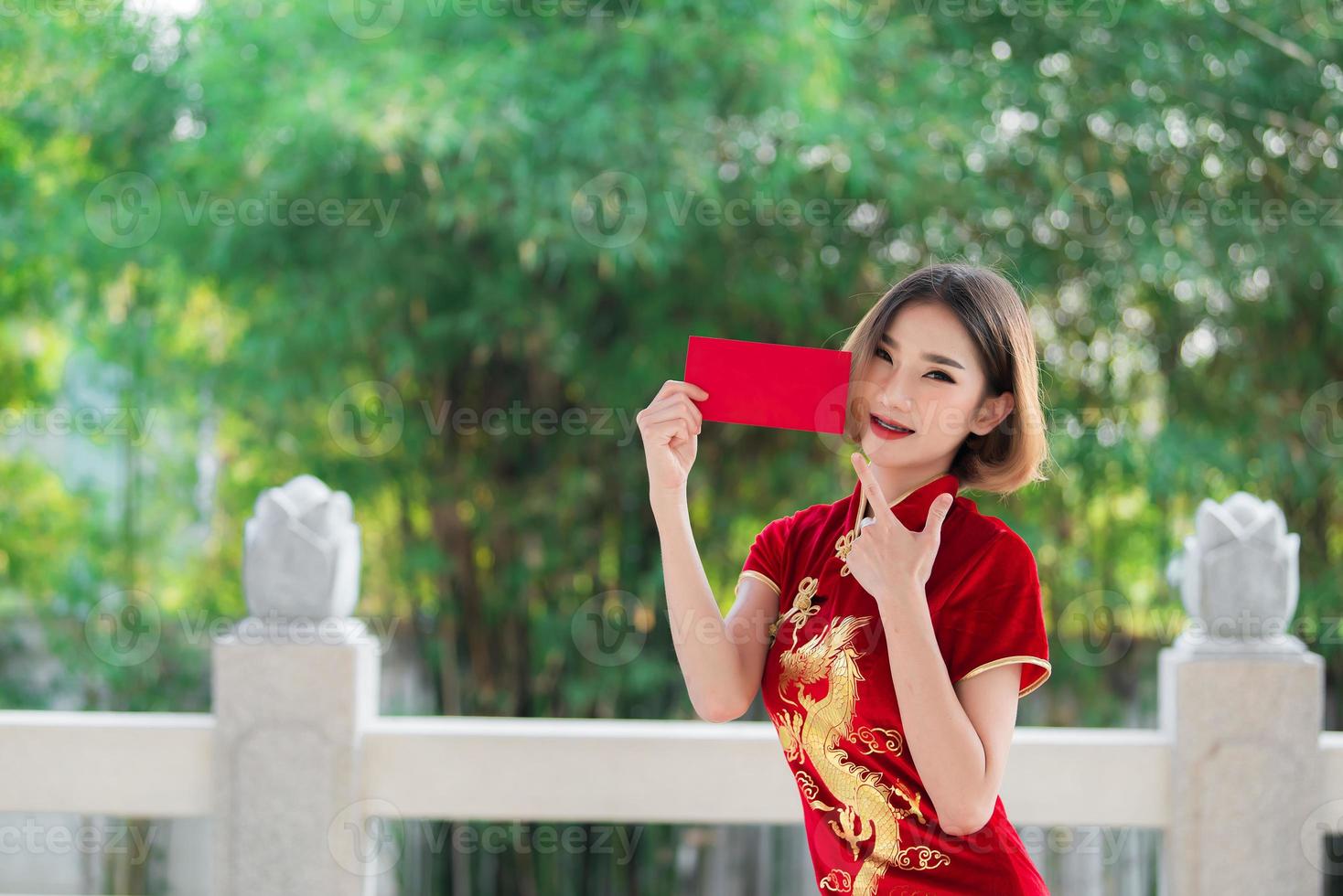 porträtt vacker asiatisk kvinna i cheongsam klänning, thailändska människor, gott kinesiskt nyårs koncept, glad asiatisk dam i traditionell kinesisk klänning foto