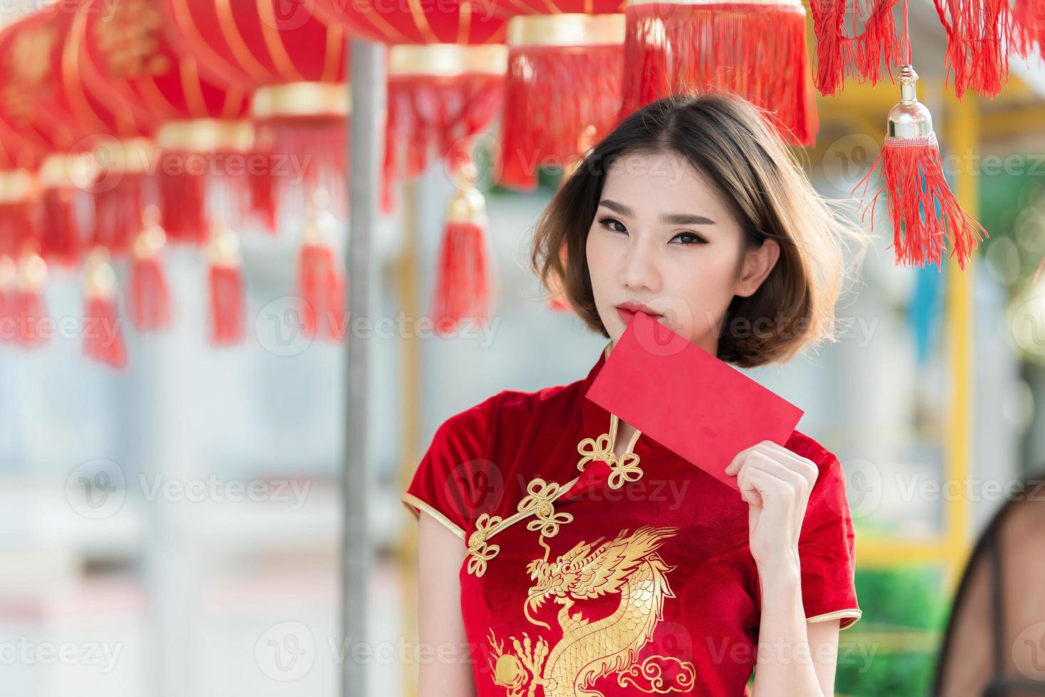 porträtt vacker asiatisk kvinna i cheongsam klänning, thailändska människor, gott kinesiskt nyårs koncept, glad asiatisk dam i traditionell kinesisk klänning foto