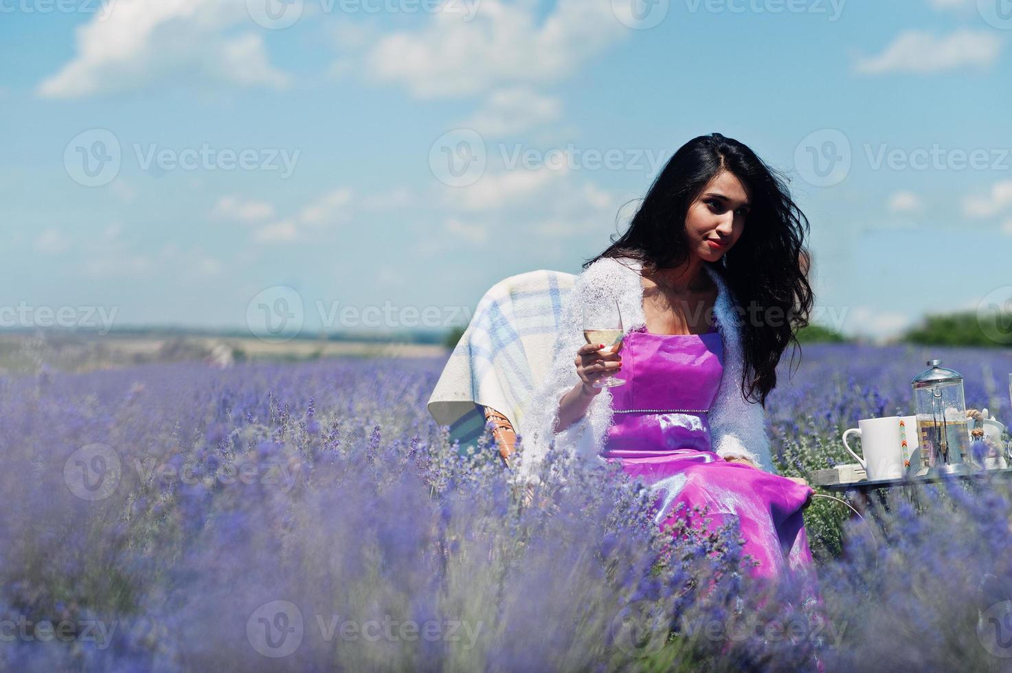 vacker indisk flicka bär saree Indien traditionell klänning sitter i lila lavendel fält med dekor. foto