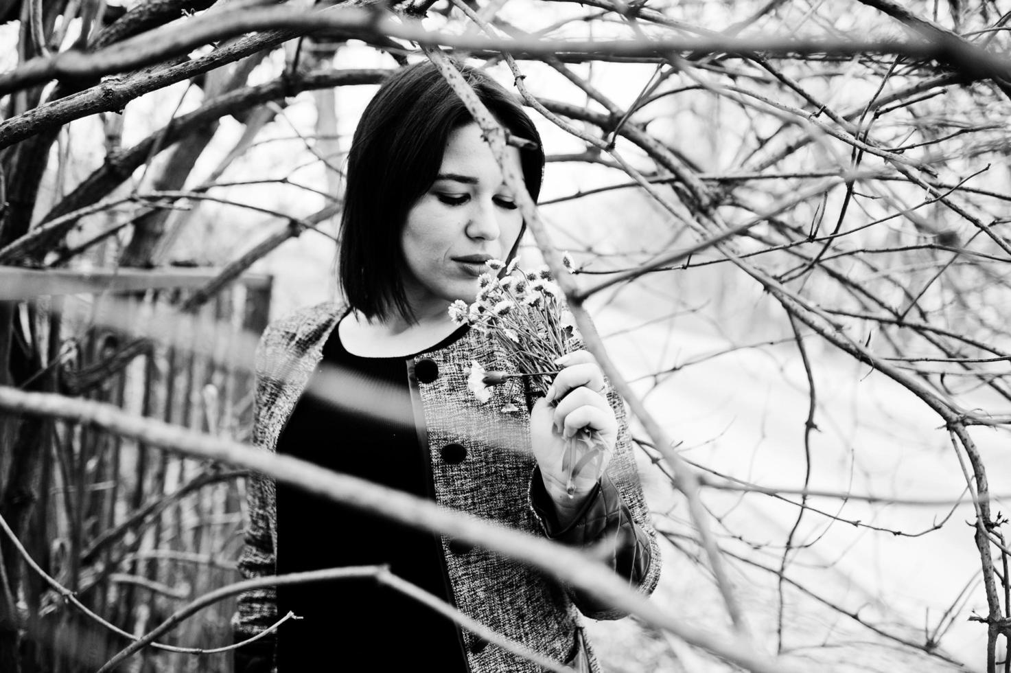 porträtt av brunett flicka i svart klänning på våren trä. foto