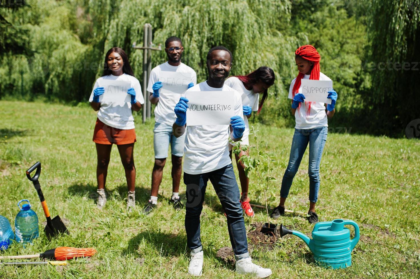 grupp glada afrikanska volontärer håller tom tavla med volontärskylt i parken. Afrika volontärarbete, välgörenhet, människor och ekologi koncept. foto