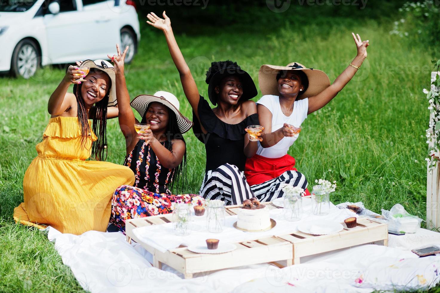 grupp afroamerikanska flickor som firar födelsedagsfest och klirrande glasögon utomhus med inredning. foto