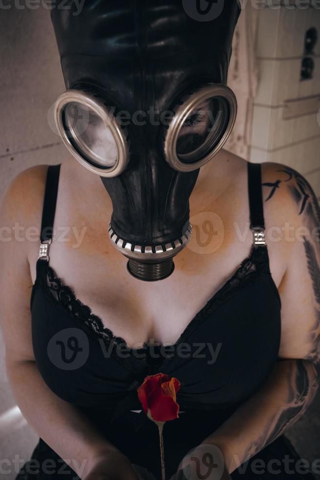 kvinna med gasmask och en ros foto