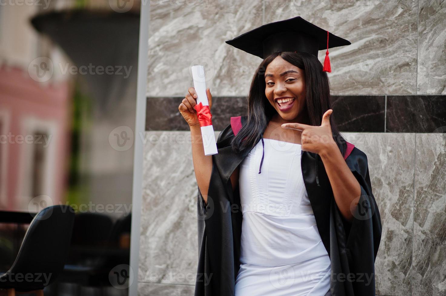 ung kvinnlig afroamerikansk student med diplom poserar utomhus. foto