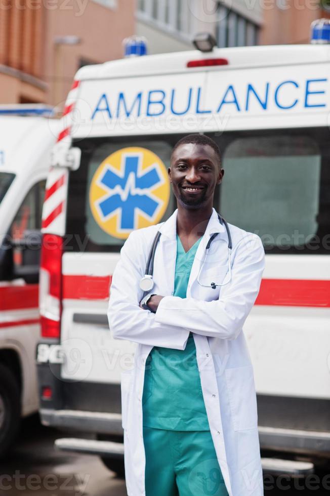 afrikansk manlig sjukvårdare står framför ambulansbil. foto