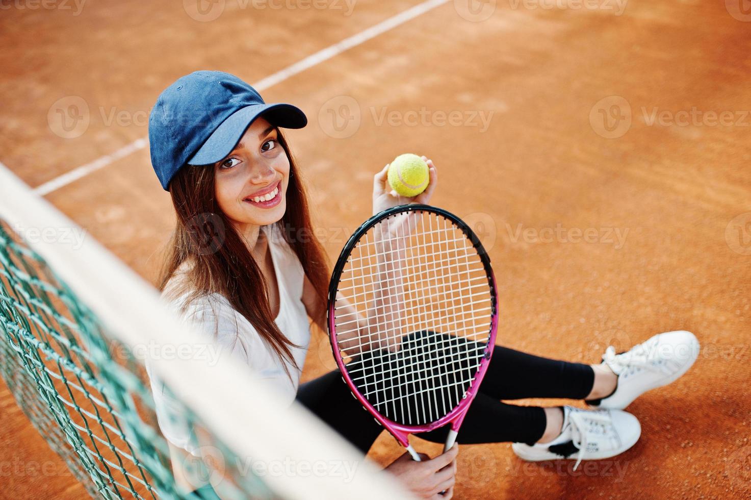 ung sportig tjejspelare med tennisracket på tennisbanan. foto