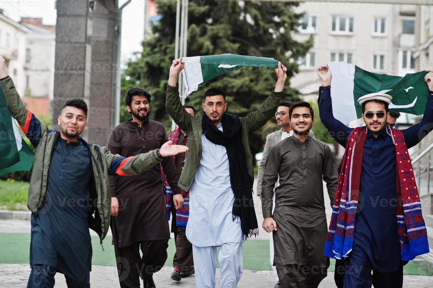 grupp av pakistanska man bär traditionella kläder salwar kameez eller kurta med pakistanska flaggor. foto