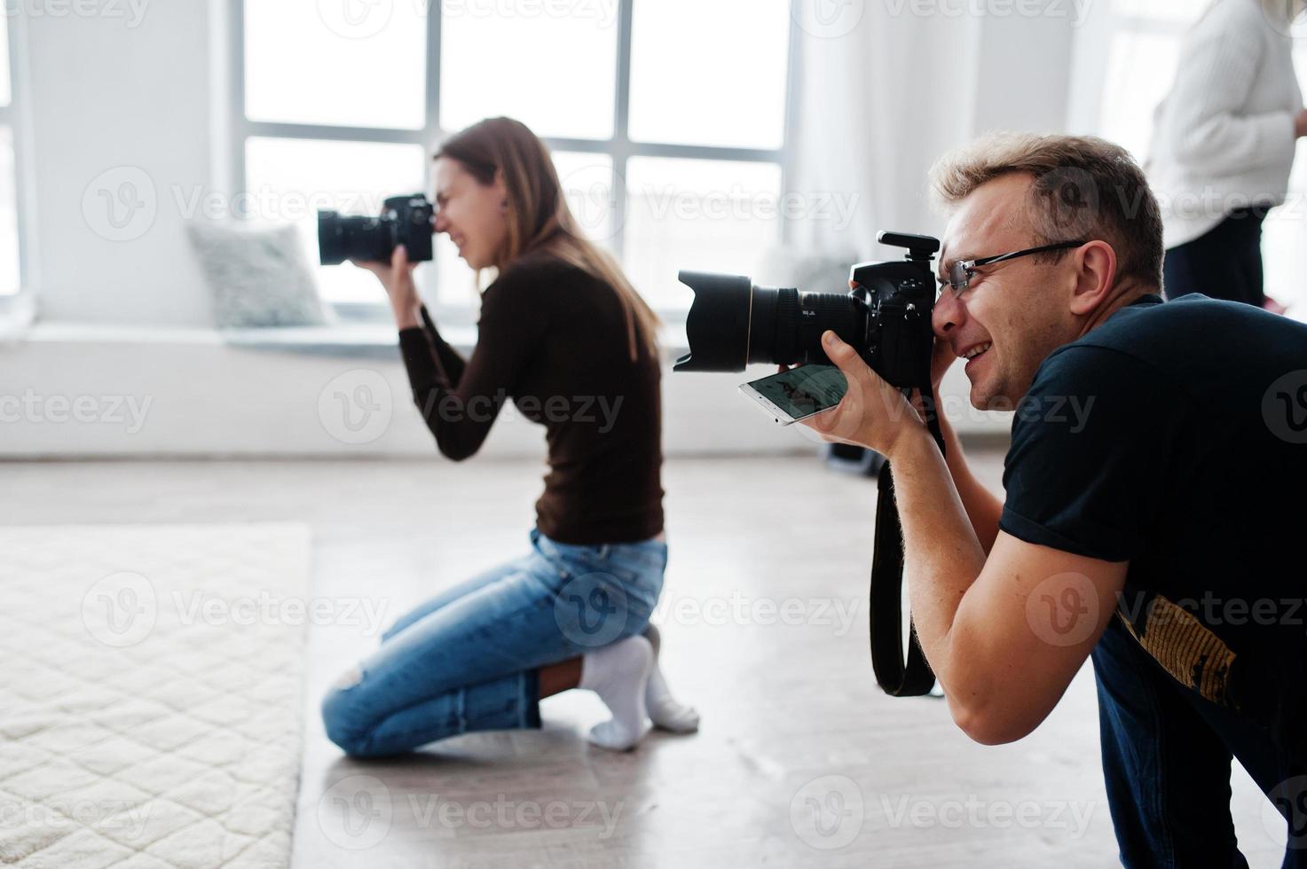 teamet av två fotografer som fotograferar i studio. professionell fotograf på jobbet. foto