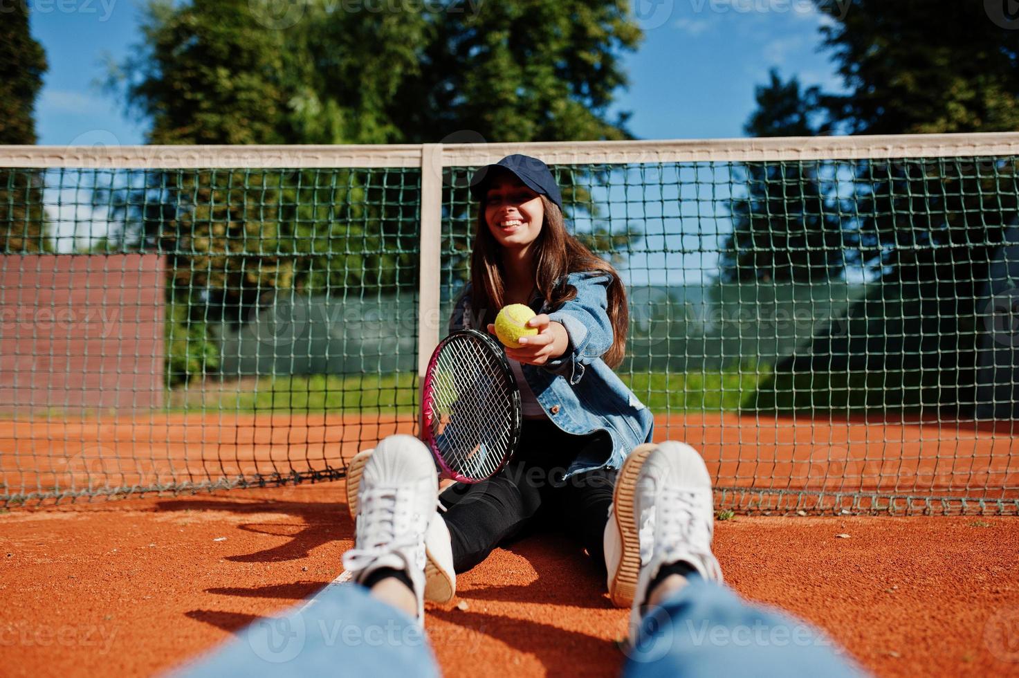 ung sportig tjejspelare med tennisracket på tennisbanan. foto