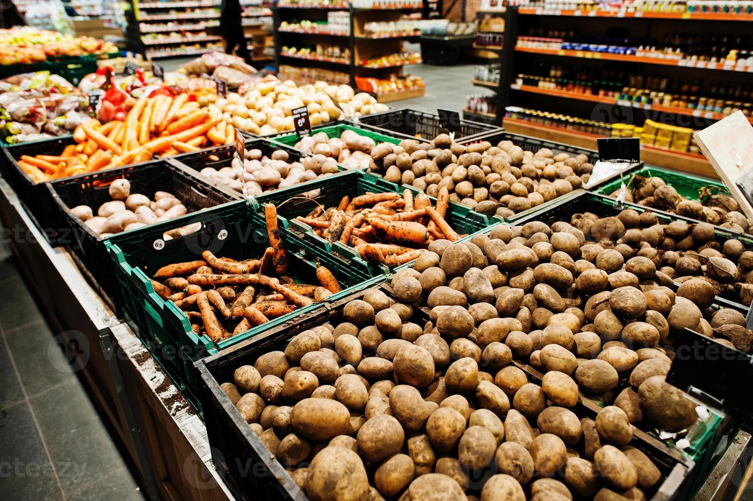 potatis, morot och andra grönsaker på lådor på snabbköpet. foto