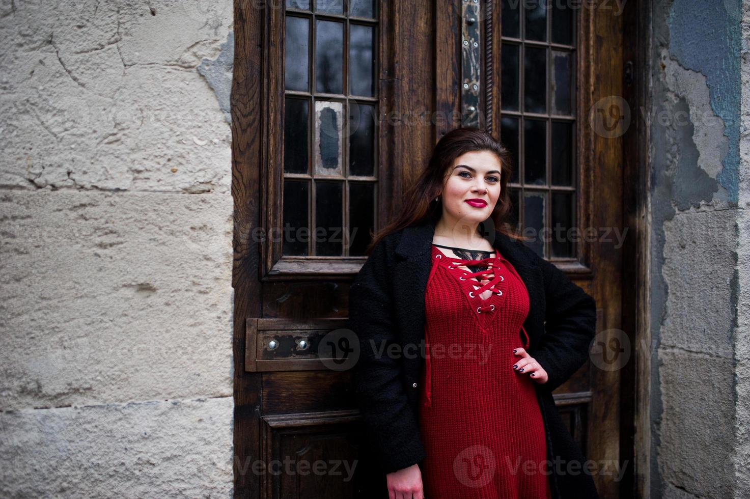 brunett plus size modell på rött på gatan i staden. foto