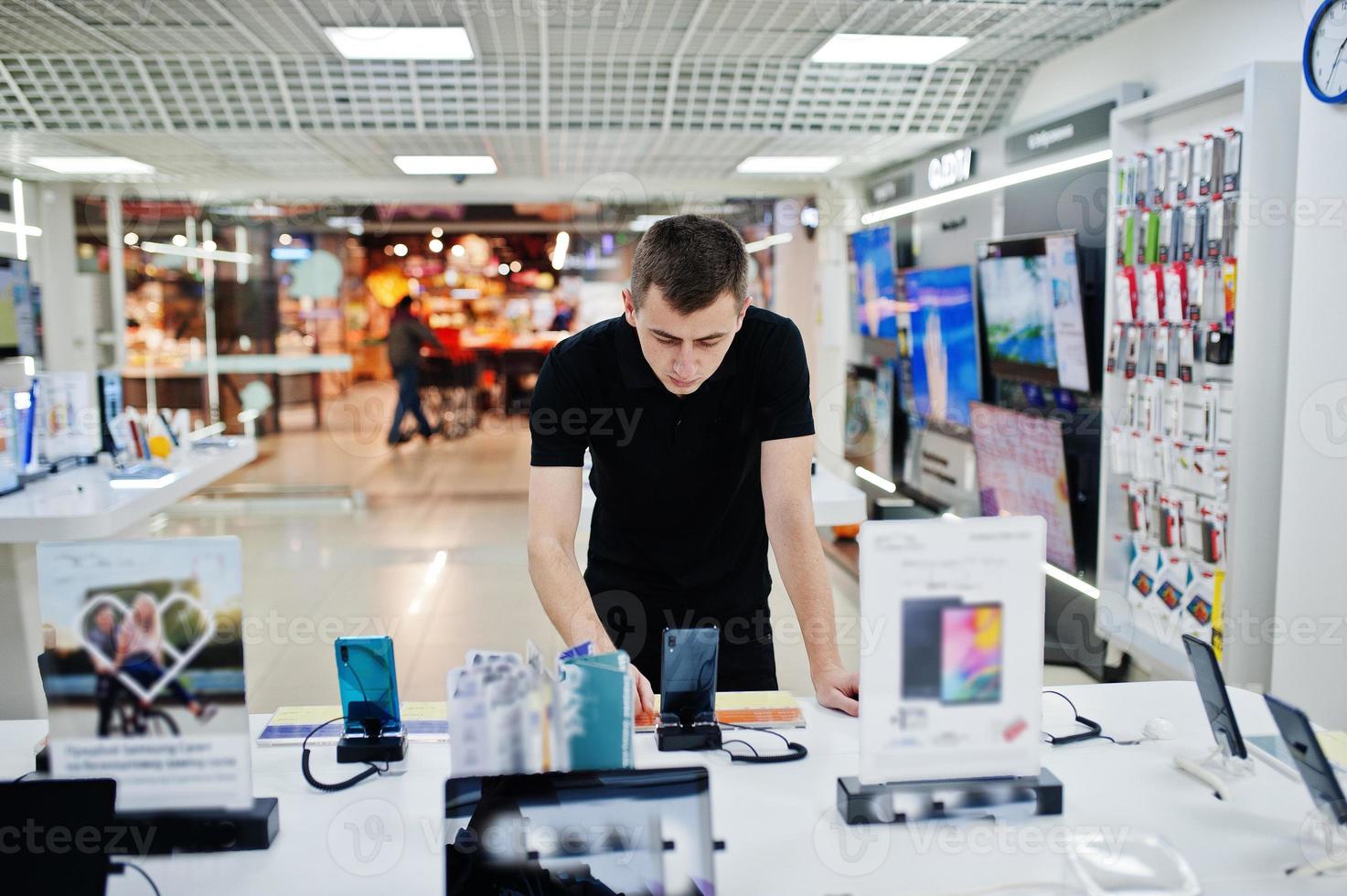 säljare man mobiltelefon professionell konsult i teknisk butik eller butik. foto