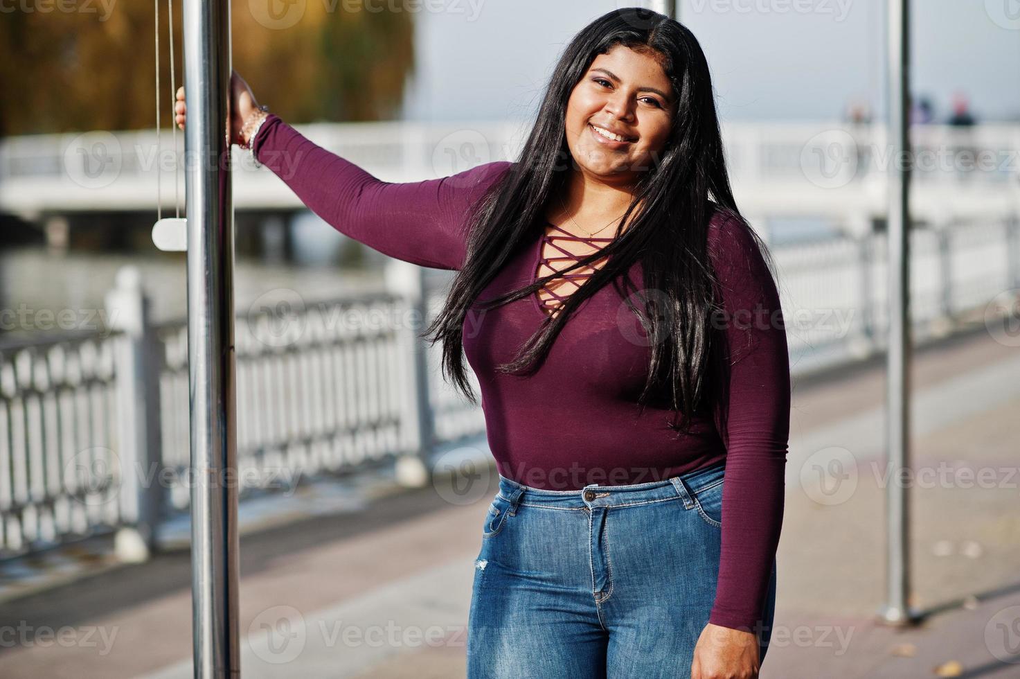 söt latino xxl modell tjej från ecuador bär på violett blus poserade mot sjön. foto