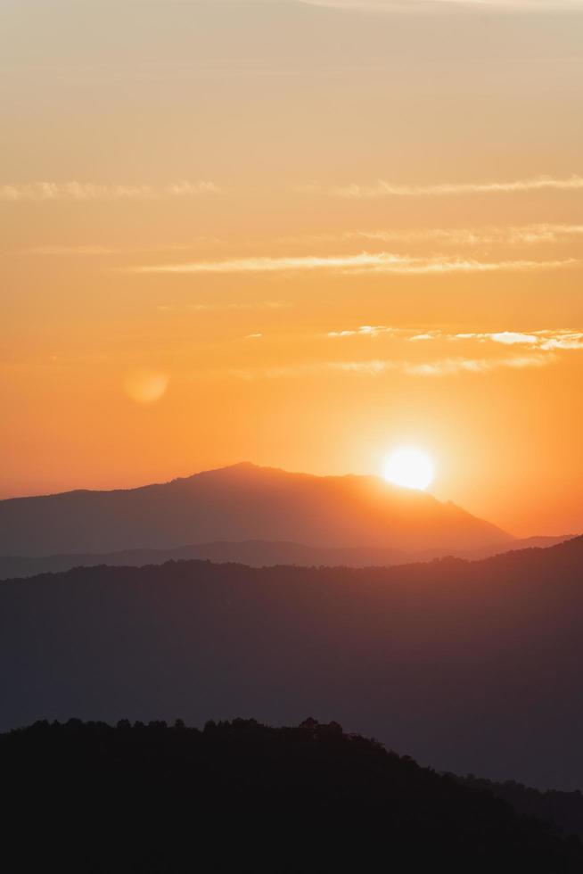 solnedgångslandskap med berg och sol guldbelysning under livfull färgglad kvällshimmel i bergen. natur berg himmel och moln solnedgång koncept foto