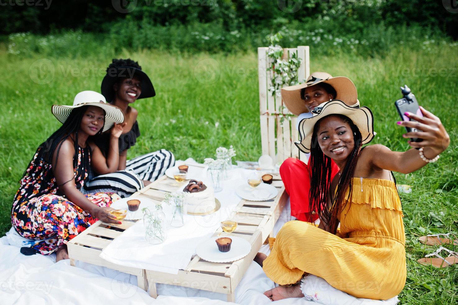 grupp afroamerikanska flickor som firar födelsedagsfest utomhus med inredning. göra selfie på telefonen. foto