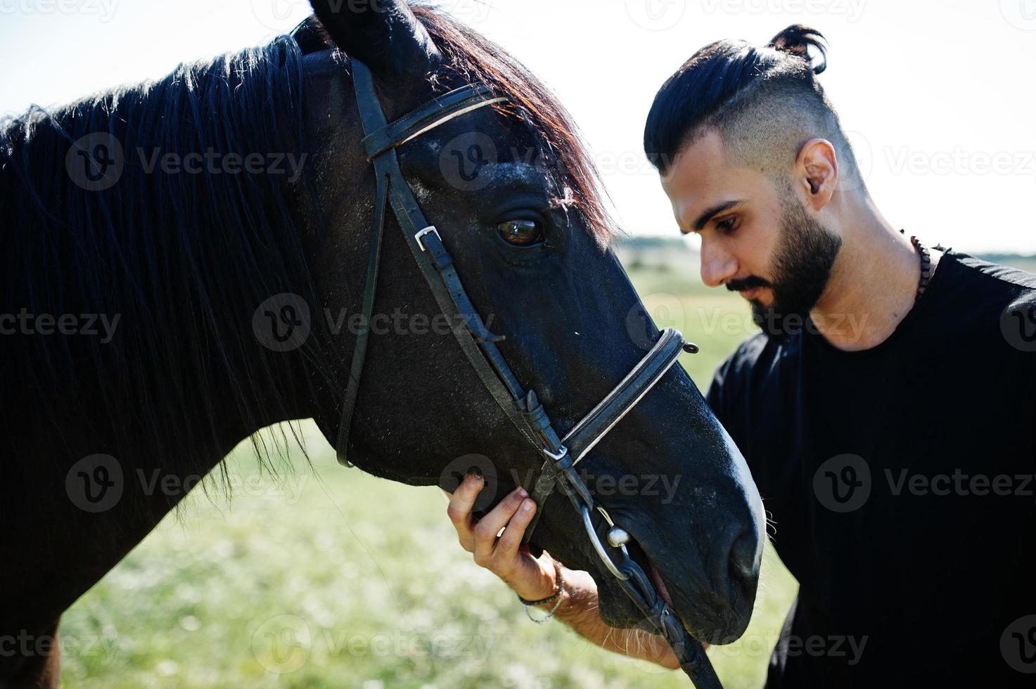 arabiskt högt skägg man bär i svart med arabisk häst. foto