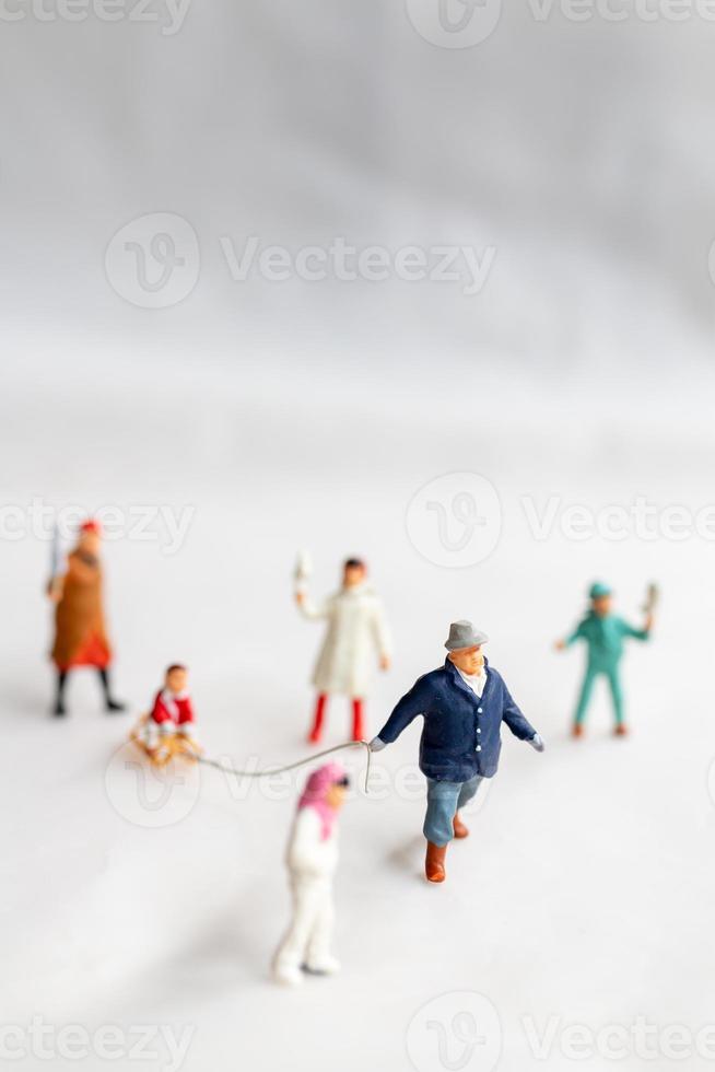 miniatyr människor lycklig familj rida en släde med snö bakgrund foto