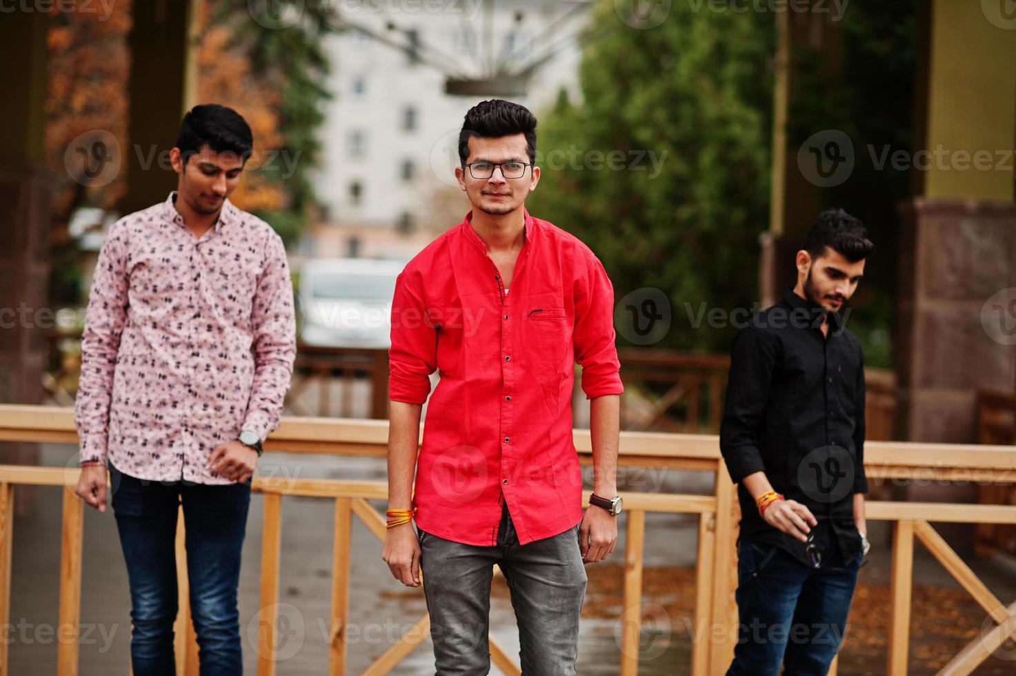 tre indiska killar studenter vänner går på gatan. foto