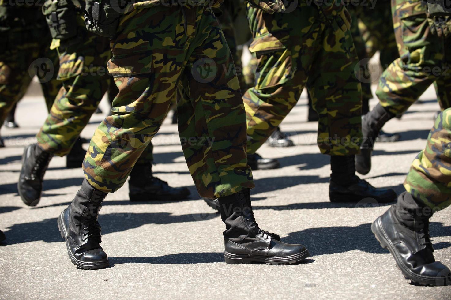 militär marscherar på en gata. ben och skor i linje foto