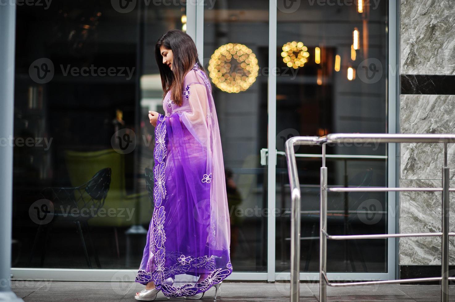 indisk hinduisk flicka på traditionella violetta saree poserade på gatan. foto