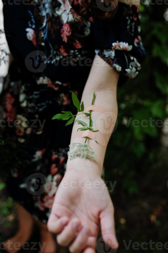 närbild av en blomma tejpad på en kvinnlig arm. foto