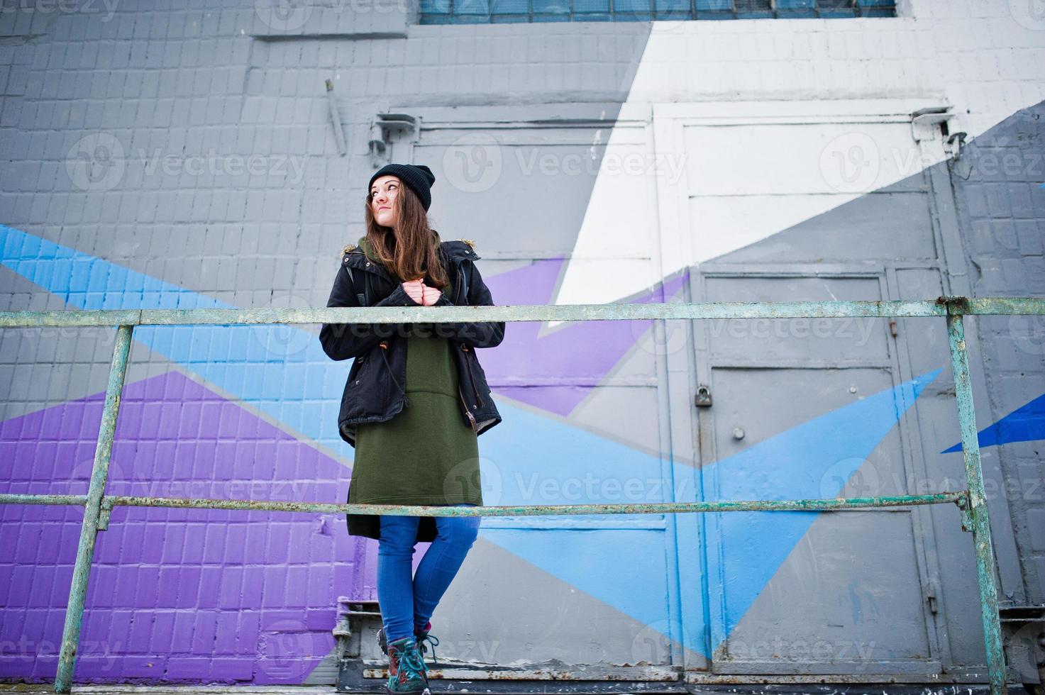 ung flicka poserade mot färgad vägg i kall dag. foto