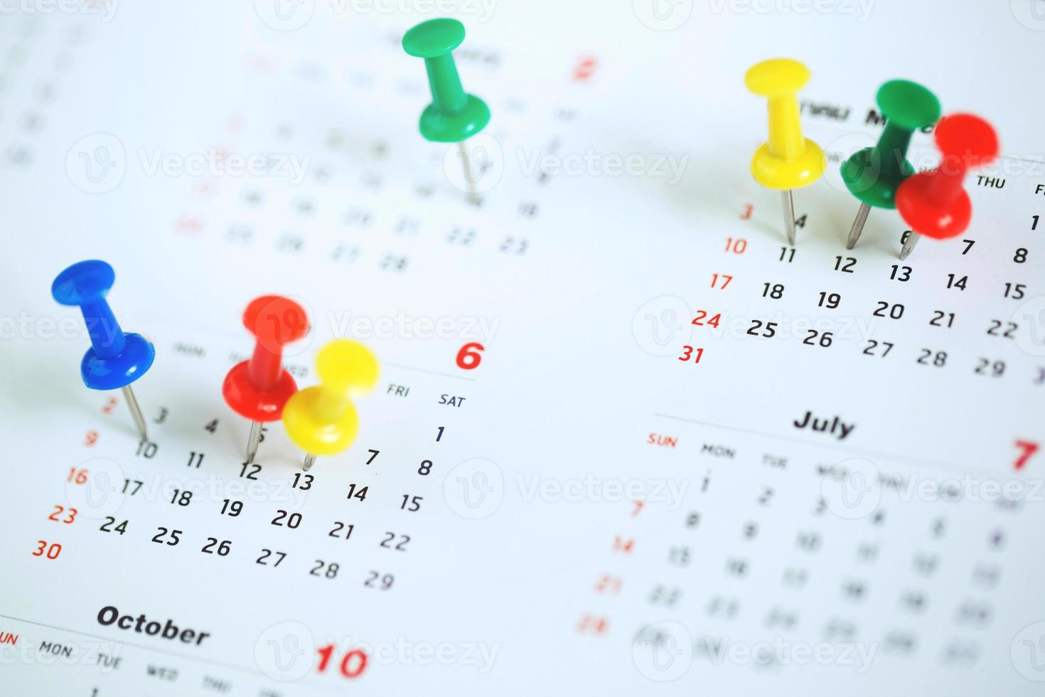 markera evenemangsdagen med en nål. häftstift i kalenderkoncept för upptagen tidslinje organisera schema, påminnelse om mötesmöte. planering affärsmöte eller resa semester planering koncept. mjukt fokus foto