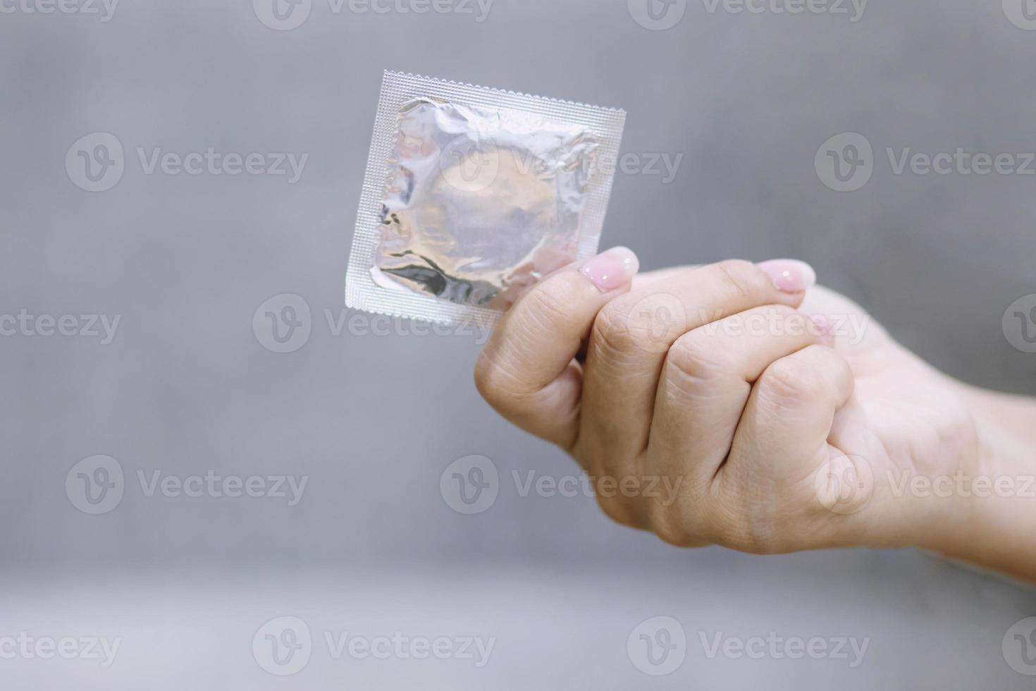 kondomer redo att användas i kvinnlig hand, ger kondom säker sex koncept på sängen förhindra infektion och preventivmedel kontrollera födelsetal eller säker profylaktisk. världsaidsdagen, lämna plats för text. foto