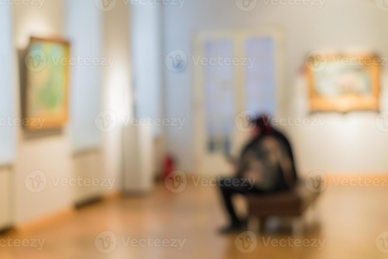 ofokuserad bild av människor som besöker konstmuseet. människor tittar på målningar på väggen foto