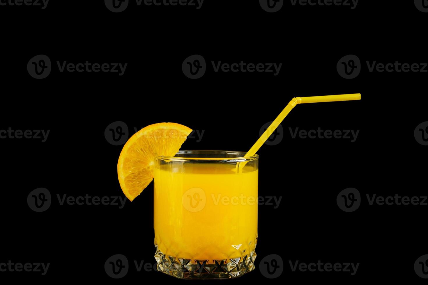 färsk hälsosam apelsinjuice i ett glas med citrusskiva och halm på svart bakgrund foto