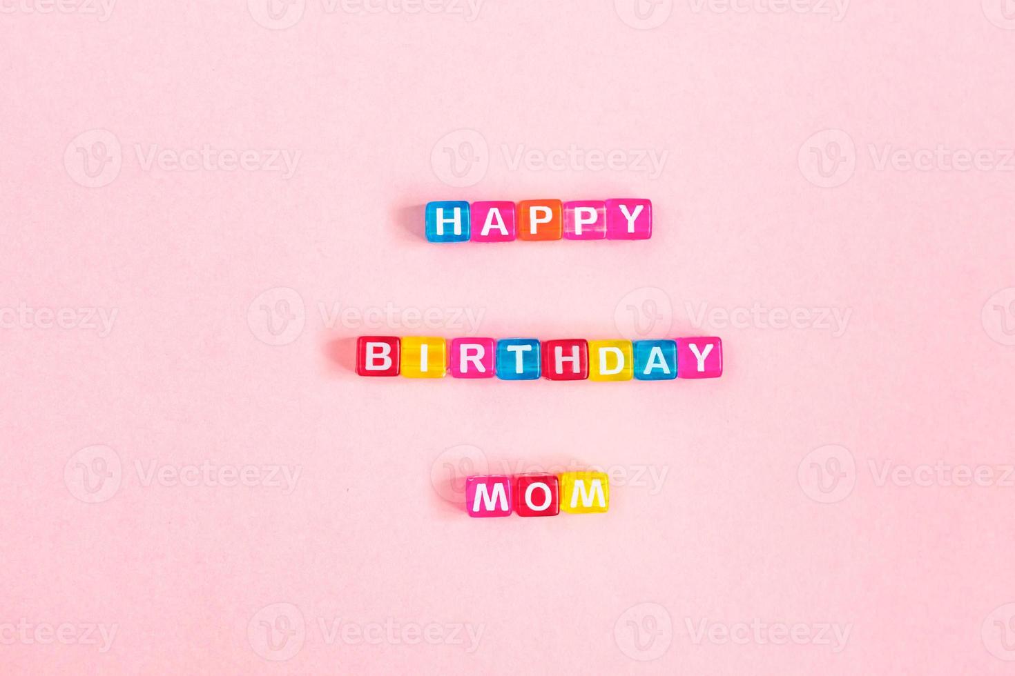 grattis på födelsedagen mamma inskription gjord av färgglada kub pärlor med bokstäver. festligt rosa bakgrundskoncept med kopia utrymme foto
