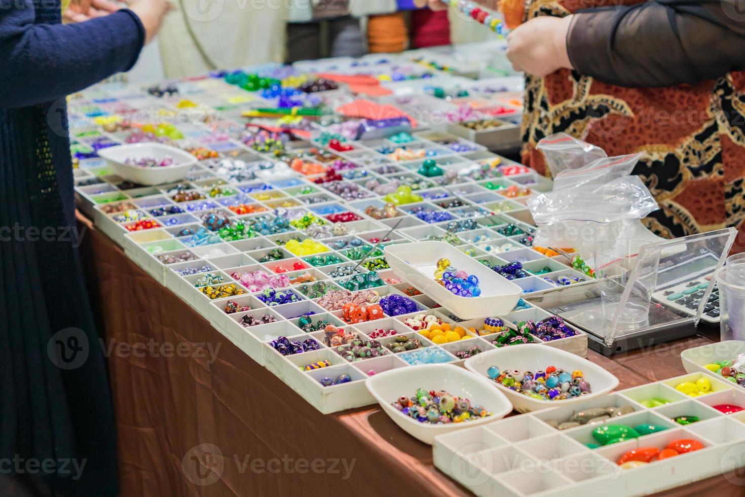 färgglad blandning av lampwork glaspärlor. olika former och färger för att göra halsband eller armband. gör-det-själv-material på marknaden foto