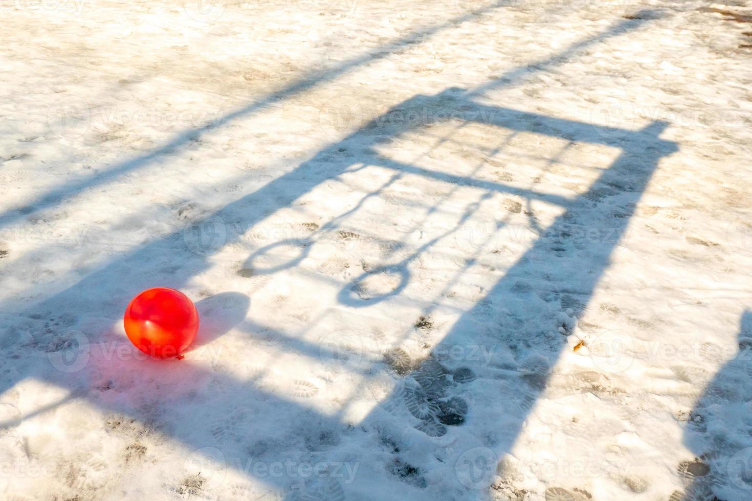 röd boll i snön på bakgrunden av skuggan av ringarna foto