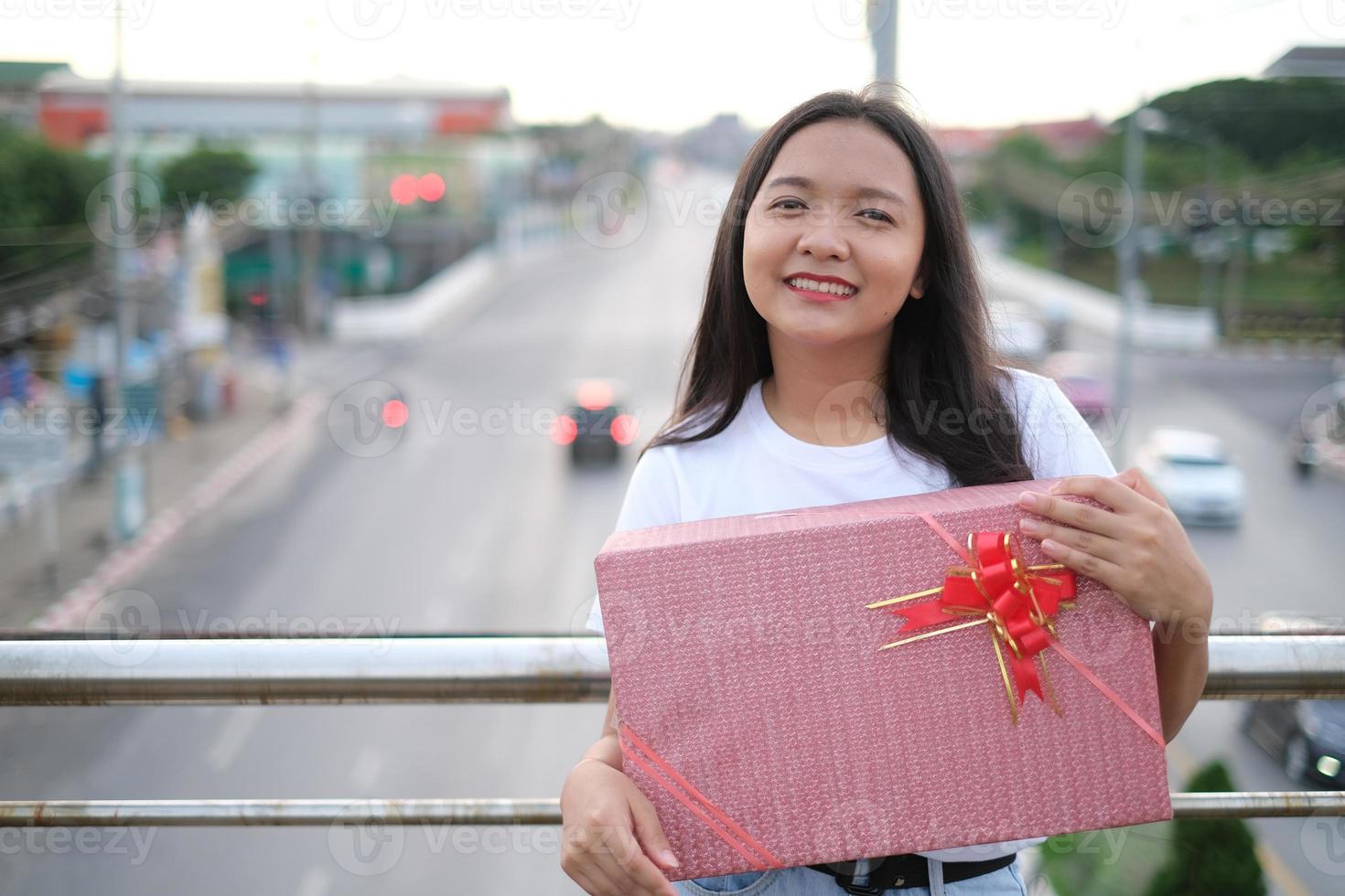 Lycklig ung flicka med gåva låda. foto
