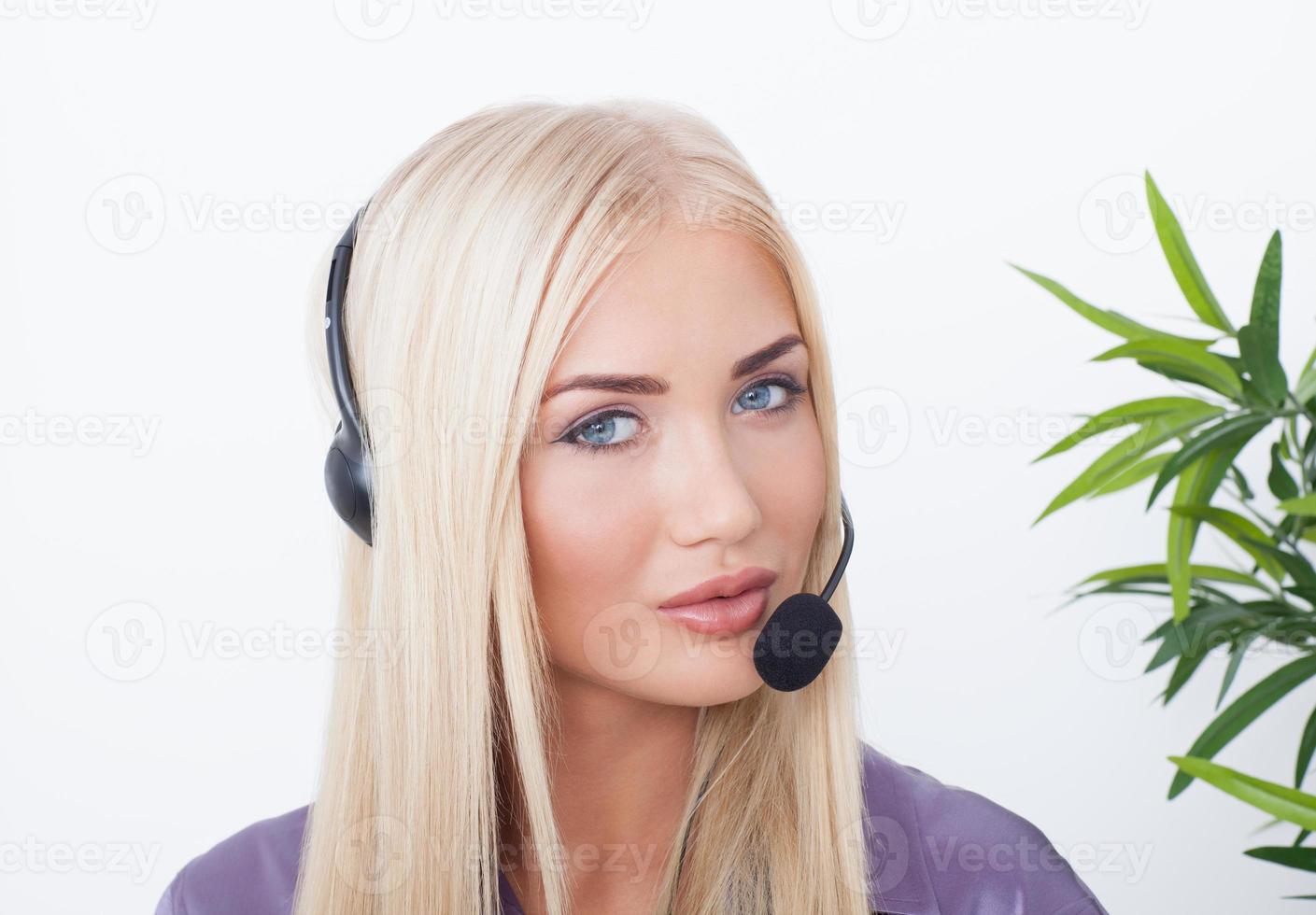 vacker blond, kvinnlig kundtjänstoperatör som använder headset foto