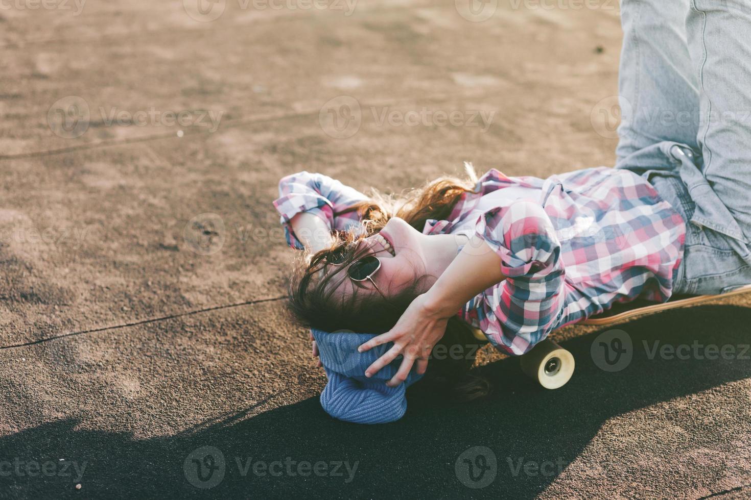 flicka i hatt lögner på skateboard, foto