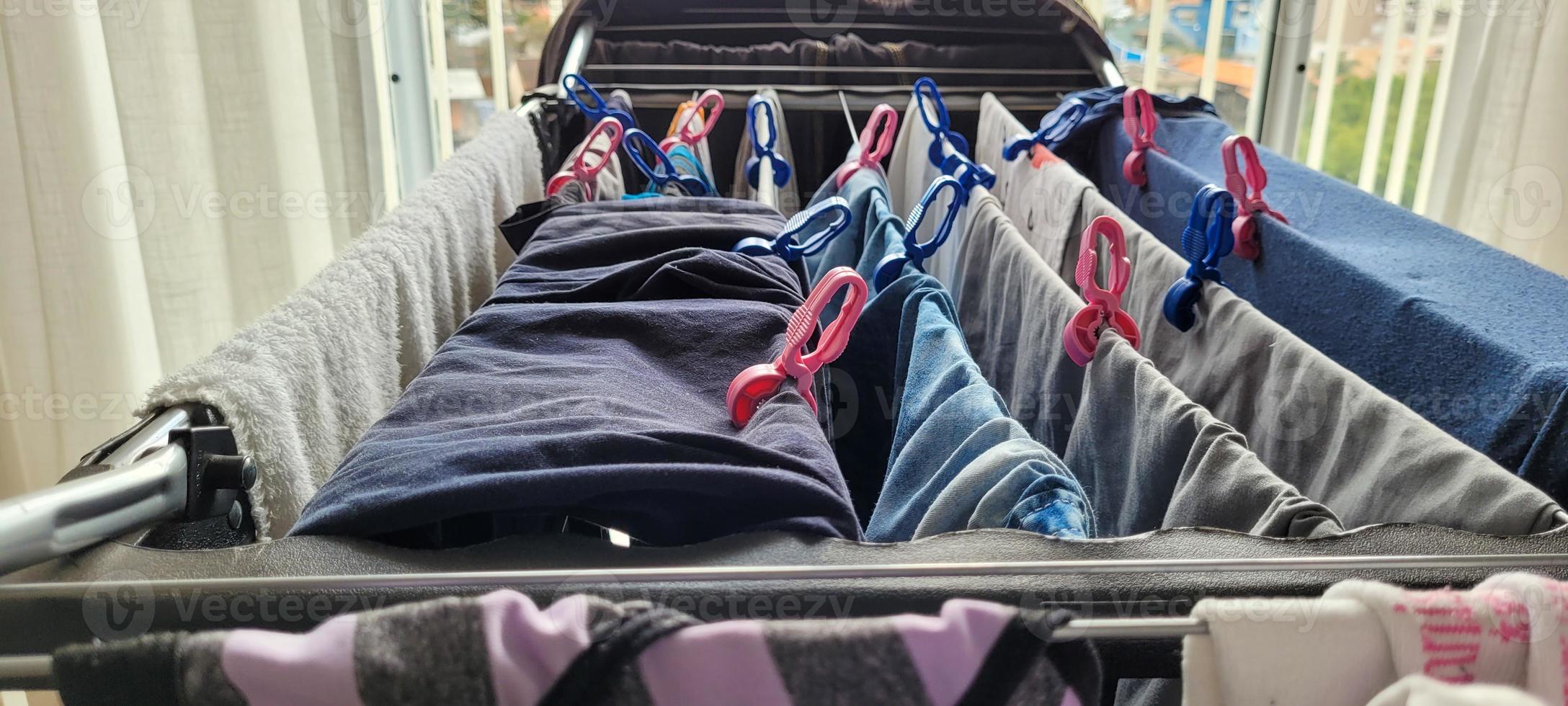 tvättades kläder hängande på klädstreck i lägenhet foto
