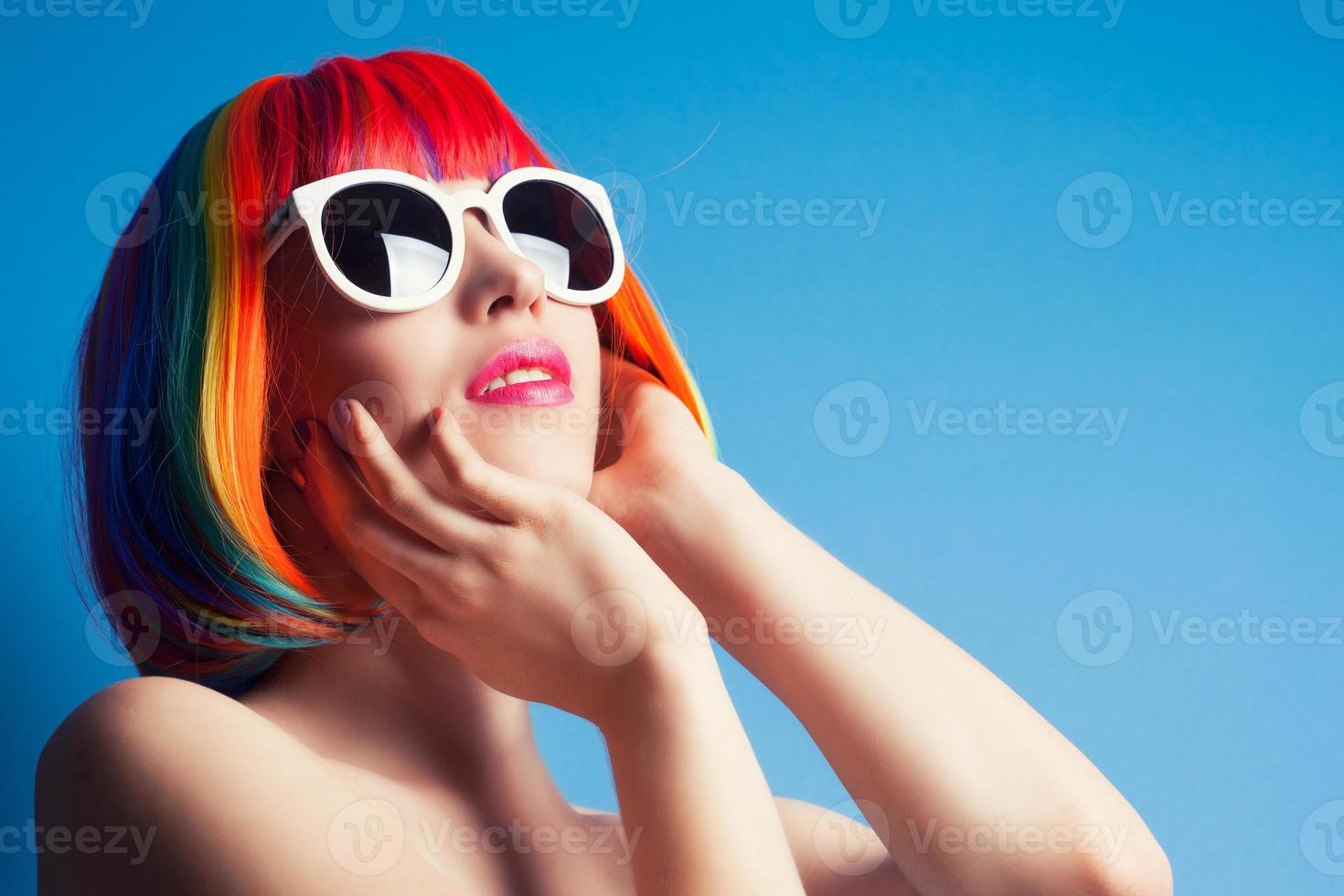 vacker kvinna som bär färgglada peruk och vita solglasögon igen foto