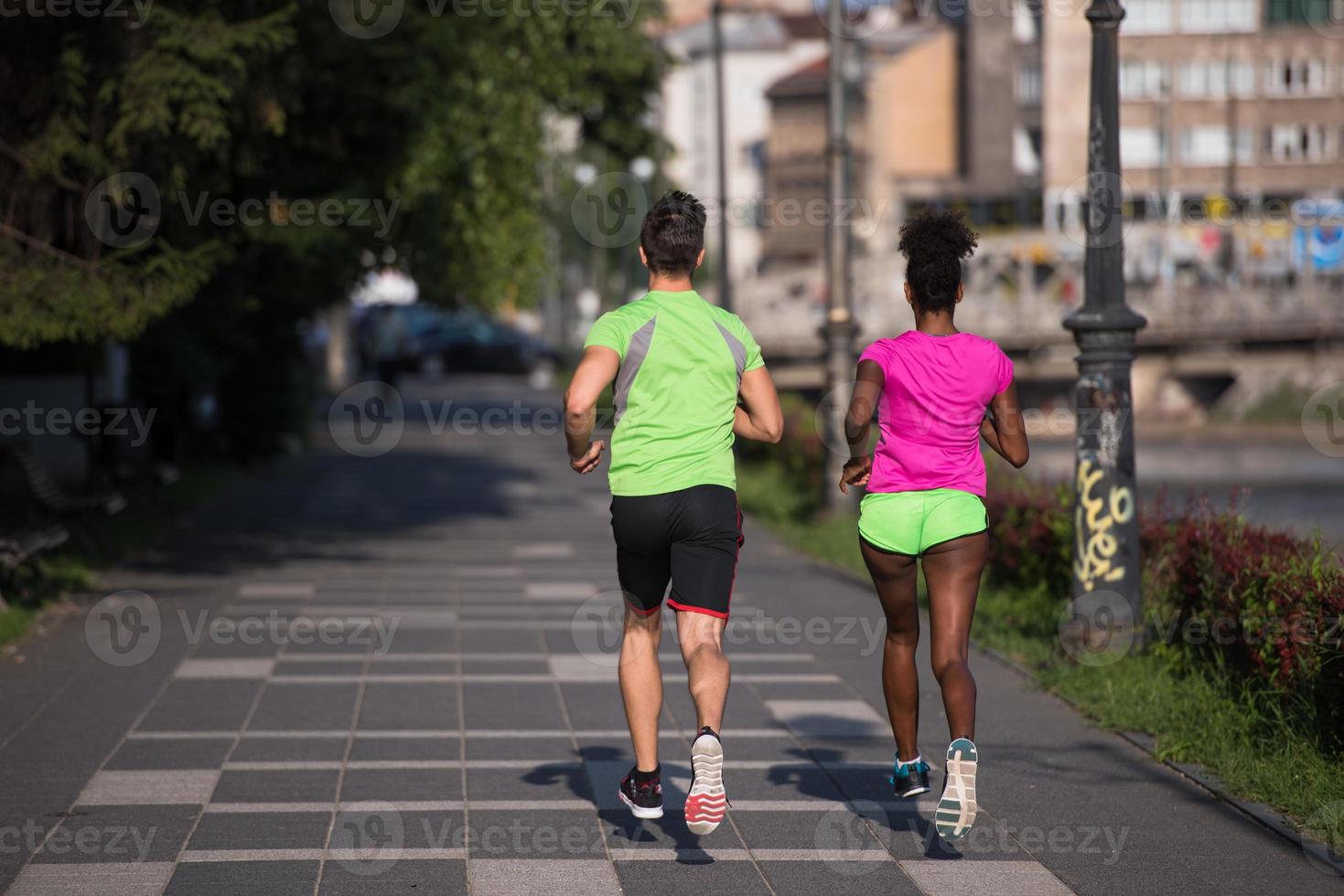 ung leende multietnisk par joggning i de stad foto