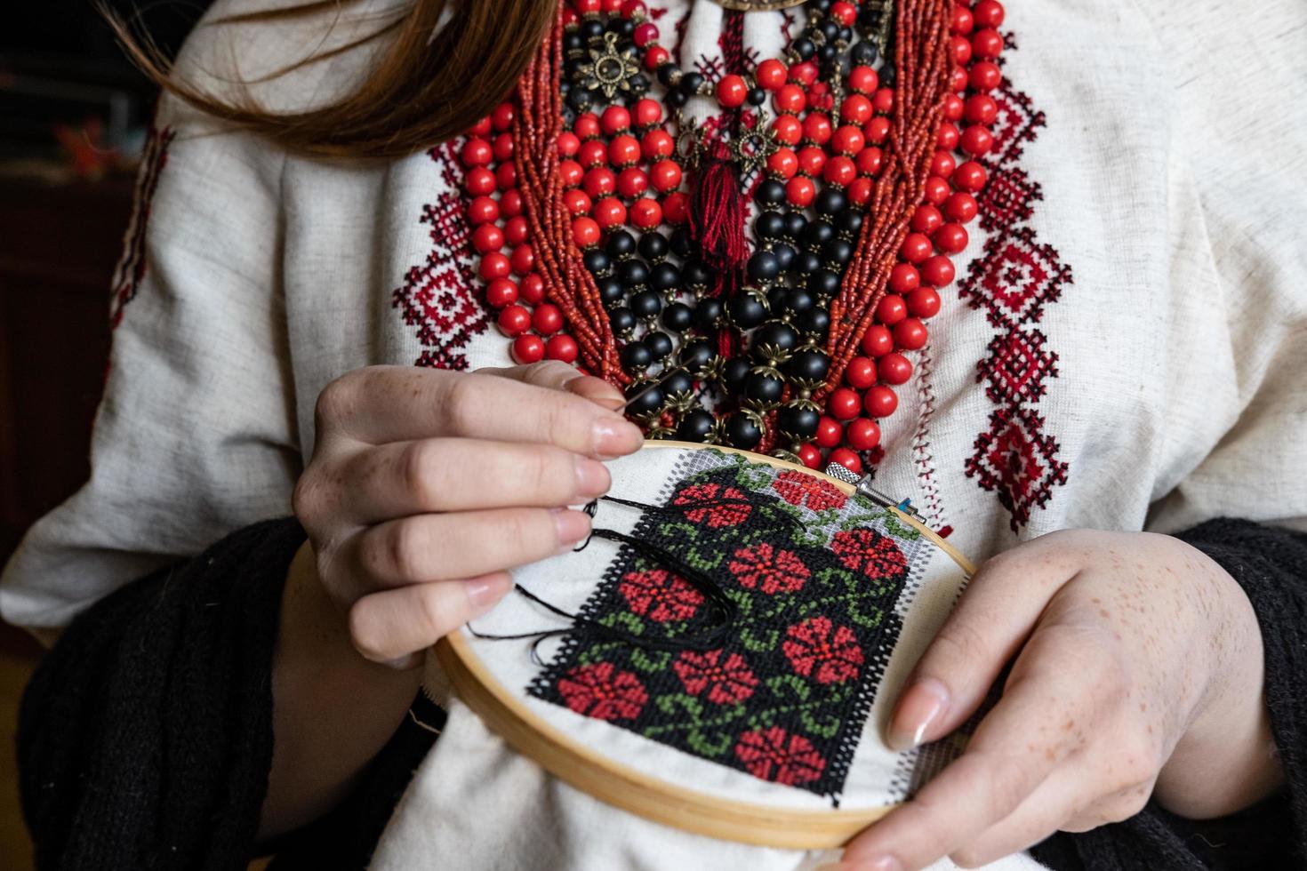 en flicka broderier en traditionell ukrainska vyshyvanka mönster foto