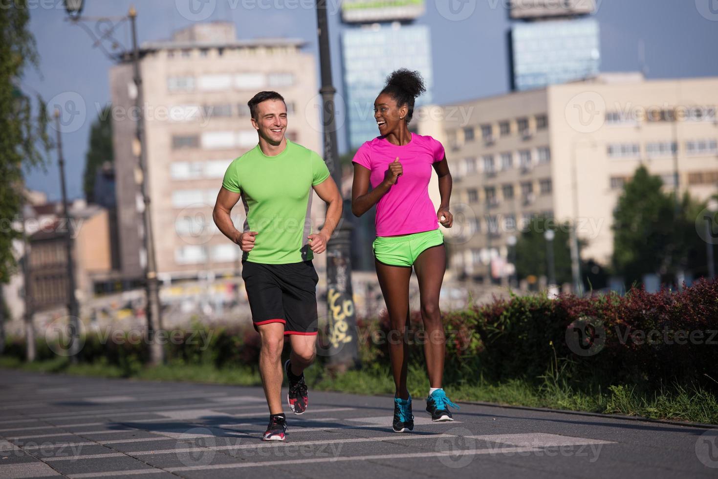 ung leende multietnisk par joggning i de stad foto